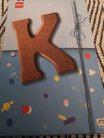 Lettre K en chocolat au lait disco-sucre pétillant